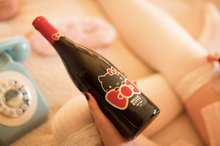 Load the image into the Gallery viewer, Hello Kitty Pinot Noir teddy bear holding a heart with "I love you"